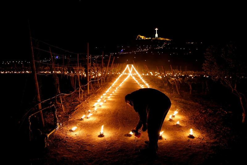 A volunteer lights flaming torches during a Seven Churches Visitation pilgrimage as part of Holy Week activities on the hill leading to Laferla Cross, one of the highest points on the Maltese islands, on Maundy Thursday outside the village of Siggiewi, Malta. Reuters