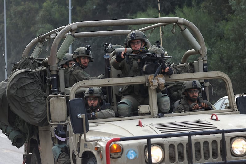 Israeli soldiers patrol a road near the border fence with Gaza. AFP