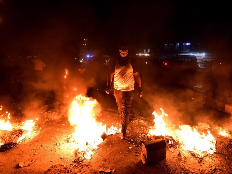 Iraqi protesters set fire to block a street during a strike and anti-government demonstrations at the Al-Tayaran Square in central Baghdad.  EPA