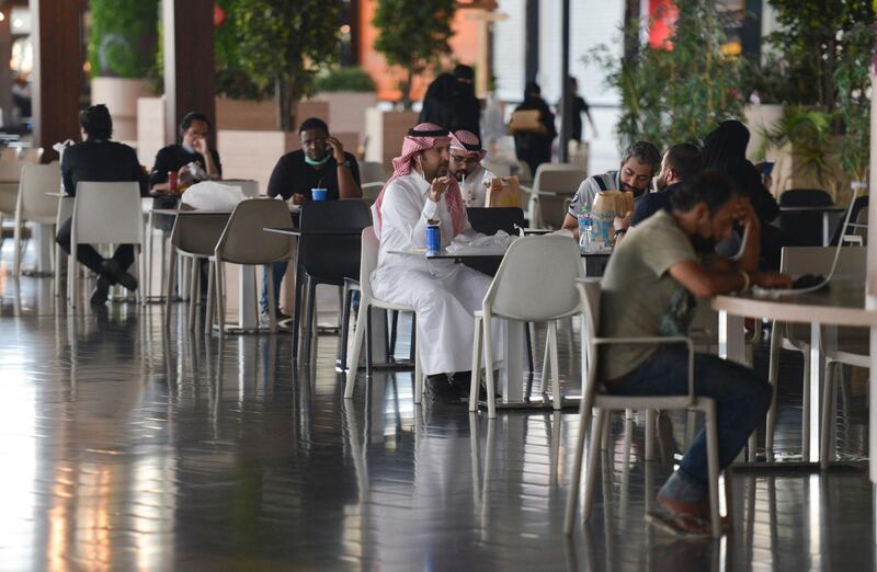People sit at a cafe in a mall in the Saudi capital Riyadh on June 4, 2020, after it reopened following the easing of some restrictions put in place by the authorities in a bid to stem the spead of the novel coronavirus. (Photo by FAYEZ NURELDINE / AFP)