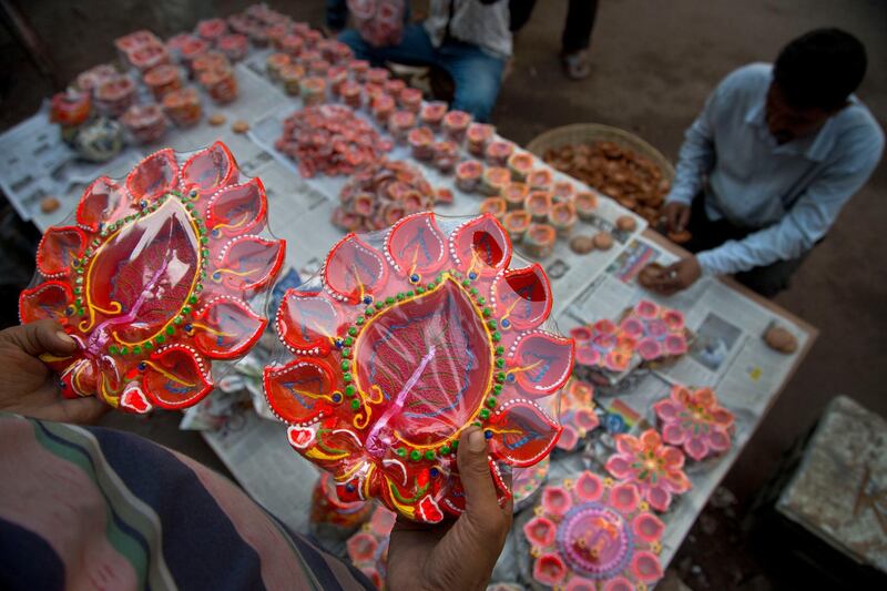 Vendors arrange decorated earthen lamps on a street ahead of Diwali festival in Gauhati, India, Saturday, Oct. 19, 2019. People buy earthen lamps to decorate their homes during Diwali, the annual Hindu festival of lights which will be celebrated on Oct 27. AP