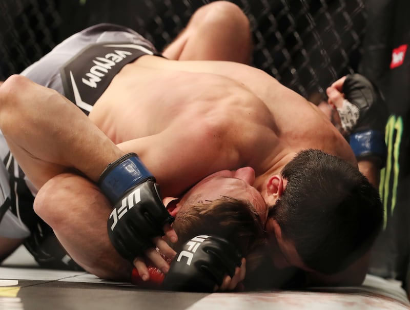 Islam Makhachev, top, wrestles Dan Hooker on his way to victory at UFC 267 in Abu Dhabi. Chris Whiteoak / The National