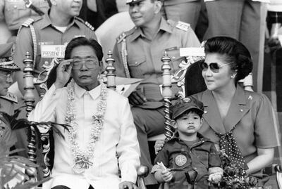 (FILES) This file photo taken on November 15, 1985 shows then Philippine president Ferdinand Marcos (L) and his wife Imelda (R) appearing before some 35,000 college students undergoing a two-year compulsory military training in Manila. The Philippine government has lost a decades-old legal effort to seize a multi-million-dollar chunk of Ferdinand Marcos' estate, a special anti-graft court said October 25, 2019, scolding prosecutors for failing to produce admissible evidence. - 
 / AFP / Romeo GACAD
