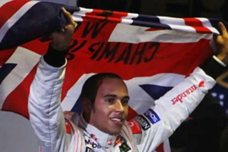 Lewis Hamilton celebrates winning the Formula One world championship by a whisker yesterday.
