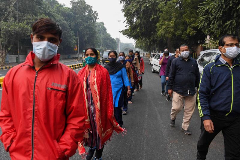 People wearing facemasks participate in a walkathon organised by Ram Manohar Lohia hospital to raise awareness on the Covid-19 coronavirus, in New Delhi. AFP