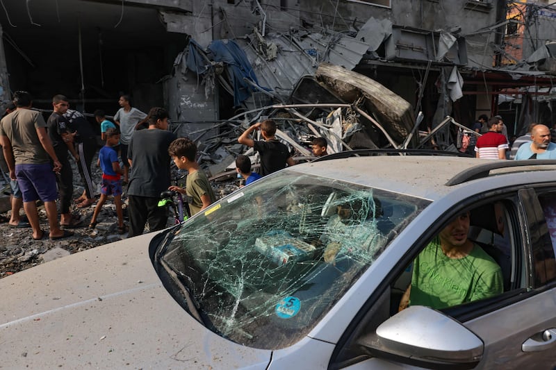 A man drives a damaged car past a building destroyed in Israeli strikes on Al Shatee camp in Gaza city. AFP