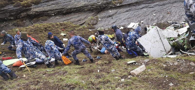 Police searchers move wreckage on the mountainside near the town of Jomsom, the plane's destination when it disappeared. EPA