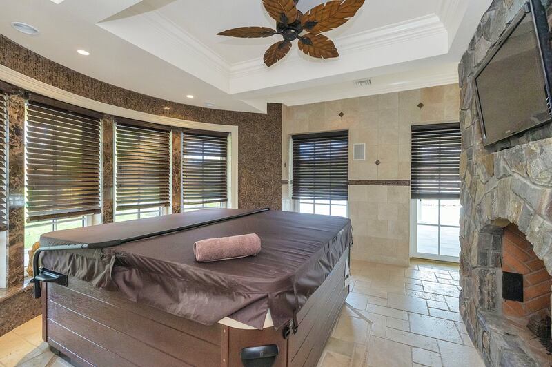 The hot tub sits in front of a TV - and another fireplace. Courtesy Douglas Elliman Realty