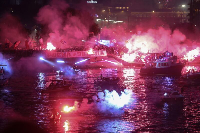 Supporters light flares on the bank of the Sava river on May 22, 2021, after Red Star Belgrade won the Serbian SuperLiga. AFP
