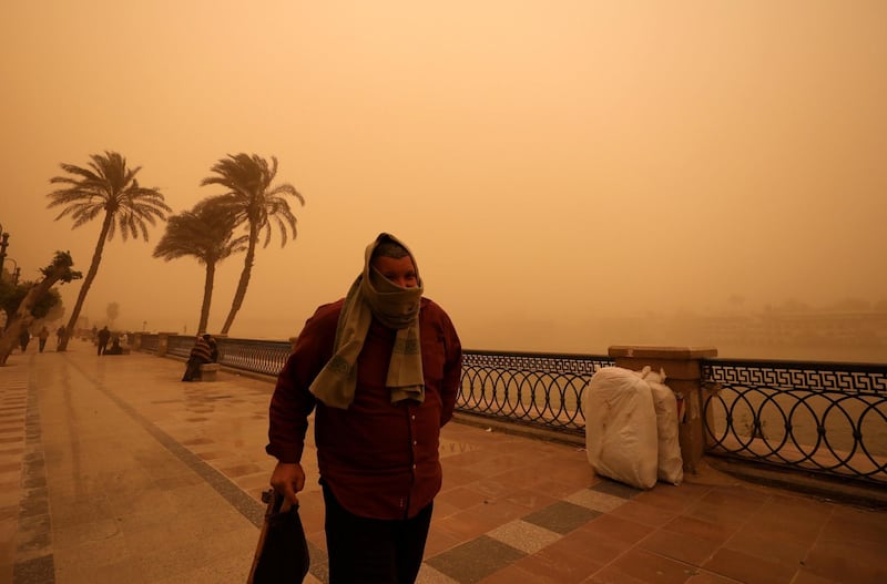 A man covers his face during a sandstorm near the River Nile in Cairo, Egypt. REUTERS