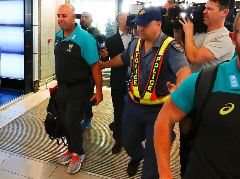 epa06631765 Australian cricket coach Darren Lehmann (L) departs from Cape Town International airport, South Africa, 27 March 2018. Australia skipper Steve Smith has been suspended by the International Cricket Council (ICC) for his part in a ball tampering scandal during the third test against South Africa. Smith admitted some senior players were aware of the ball tampering attempt. Smith and David Warner stepped down as captain and vice-captain of the Australian team in consequence to the ball meddling scandal.  EPA/NIC BOTHMA