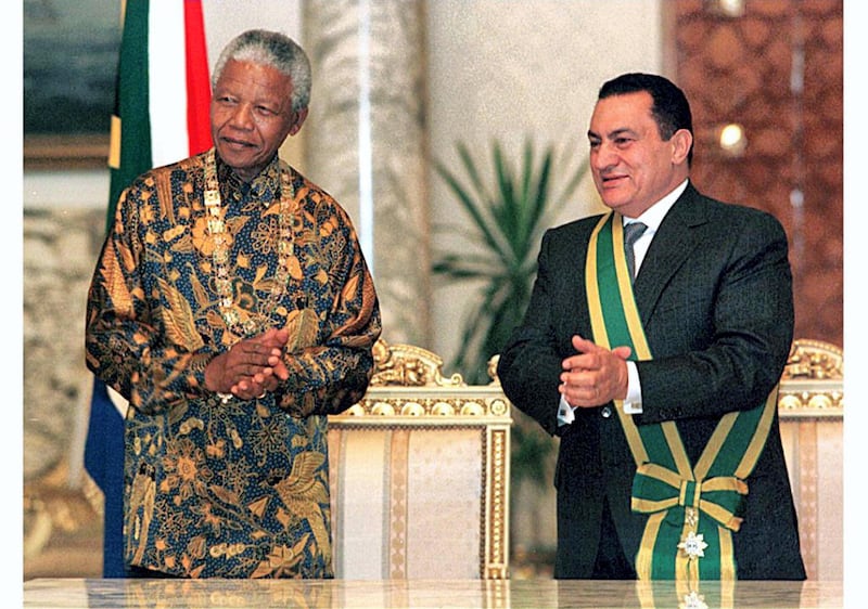 South African President Nelson Mandela (L) and Egyptian President Hosni Mubarak award each other their countries highest honours, 21 October in Cairo. Mandela received the Collar of the Nile while Mubarak was presented with the Order of Good Hope. The South African leader is on his first North African tour which will also take him to Libya - a stop highly criticised by the US. (Photo by STR / AFP)