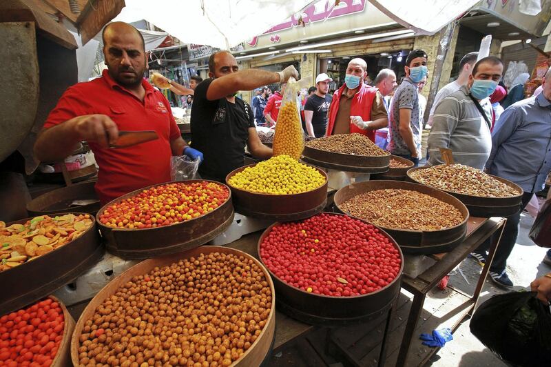 Residents shop at a market ahead of the Muslim holy month of Ramadan, during the novel coronavirus pandemic crisis in the Jordanian capital Amman, on April 23, 2020. (Photo by Khalil MAZRAAWI / AFP)