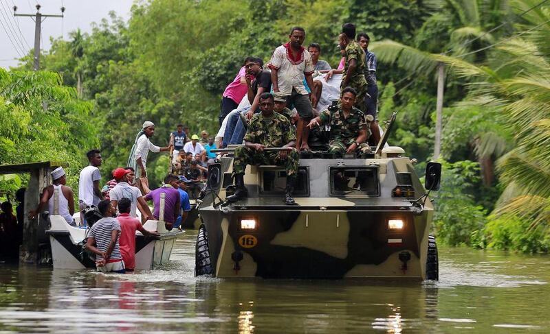 Sri Lankan soldiers evacuate flood victims while also carrying relief material, at a flooded area in Wehangalla village in Kalutara district. Eranga Jayawardena / AP Photo