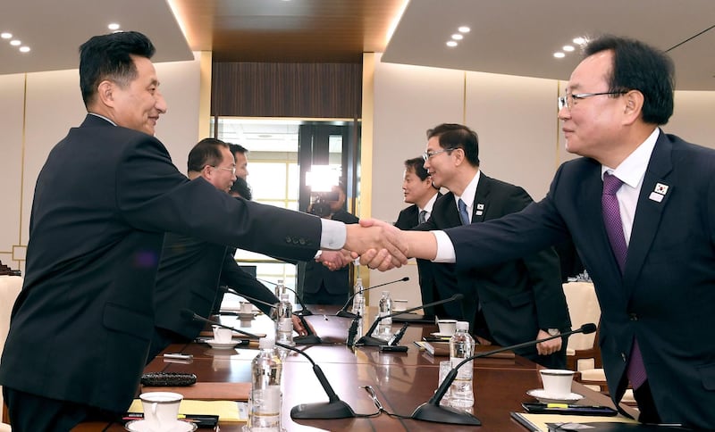 In this photo provided by South Korea Unification Ministry, South Korean Vice Unification Minister Chun Hae-sung, center right, shakes hands with the head of North Korean delegation Jon Jong Su during their meeting at Panmunjom in the Demilitarized Zone in Paju, South Korea, Wednesday, Jan. 17, 2018. The two Koreas are meeting Wednesday for the third time in about 10 days to continue their discussions on Olympics cooperation, days ahead of talks with the IOC on North Korean participation in the upcoming Winter Games in the South. (South Korea Unification Ministry via AP)