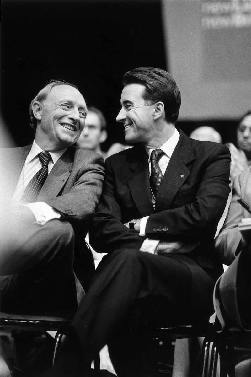 Former leader Neil Kinnock, left, shares a joke with Peter Mandelson, a key figure behind the party's 1997 general election landslide victory, at the party conference in 1997