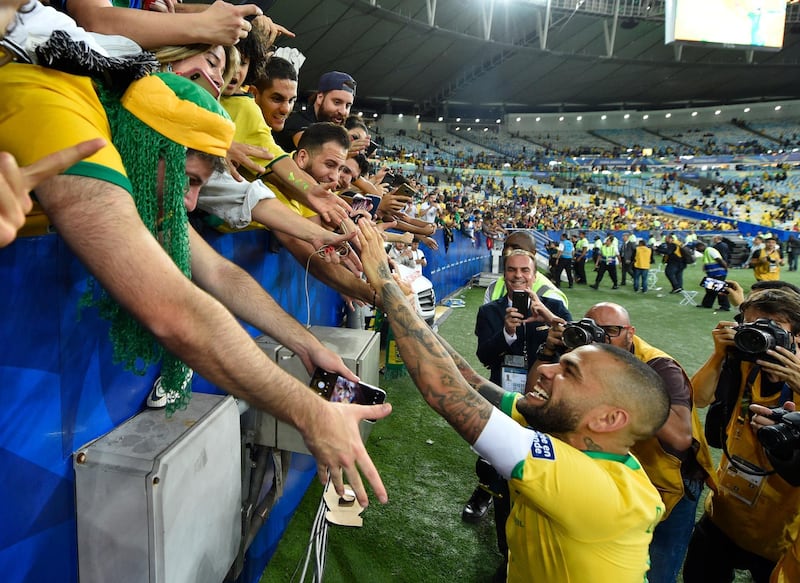 Dani Alves celebrates with fans. Getty