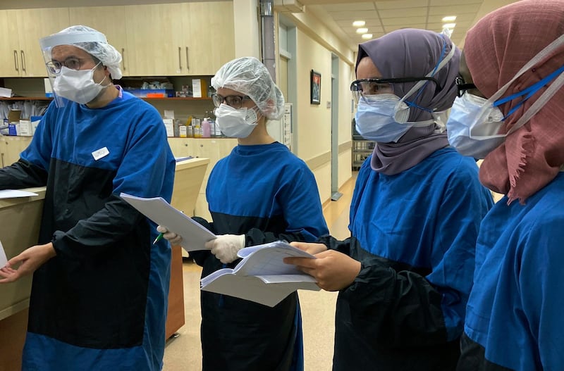 Medical personnel participate in a briefing at Istanbul University Cerrahpasa - Cerrahpasa Medical Faculty Hospital's ward dedicated to patients with coronavirus (COVID-19) in Istanbul, Tuesday, April 28, 2020. Turkey has seen a decline this week in the number of daily deaths and rates of infection since it started to grapple with the novel coronavirus pandemic last month. The government has refrained from imposing a total lockdown, fearing its negative impact on the already fragile economy. (AP Photo/Mehmet Guzel)