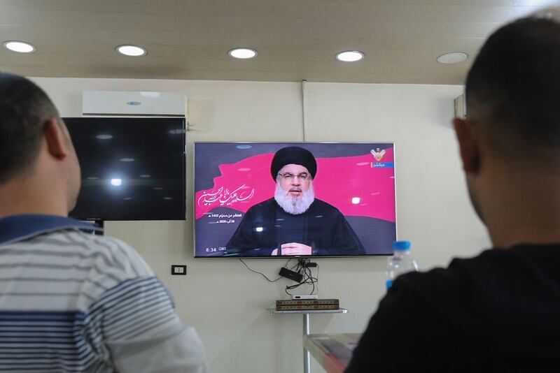 Lebanese men watch the head of the country's Shiite Muslim movement Hezbollah Hassan Nasrallah during a televised speech, at a coffee shop in the southern suburbs of the capital Beirut, on August 30, 2020, on the tenth day of the month of Muharram which marks the peak of Ashura. Ashura is a 10-day period of mourning in remembrance of the seventh-century martyrdom Imam Hussein, who was killed in the battle of Karbala in modern-day Iraq, in 680 AD. / AFP / ANWAR AMRO
