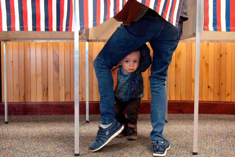 A two-year-old waits for his mother to cast her ballot at the Granby Town Hall, November 3, 2020.  AFP