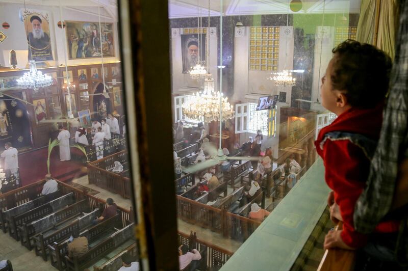 A child watches as people attend a Palm Sunday mass in Cairo, Egypt. The number of worshippers was limited because of the Covid-19 pandemic. Reuters