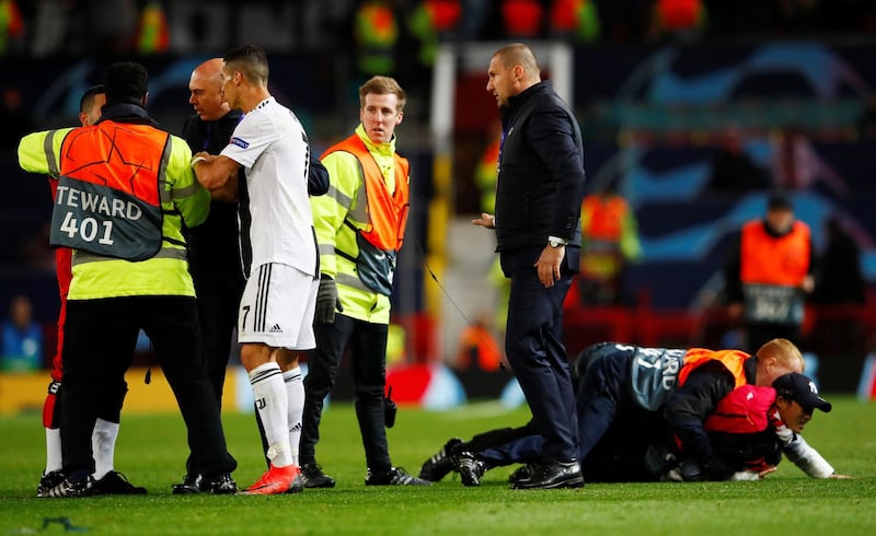 Juventus' Cristiano Ronaldo looks on as stewards apprehend pitch invaders after the match. Reuters