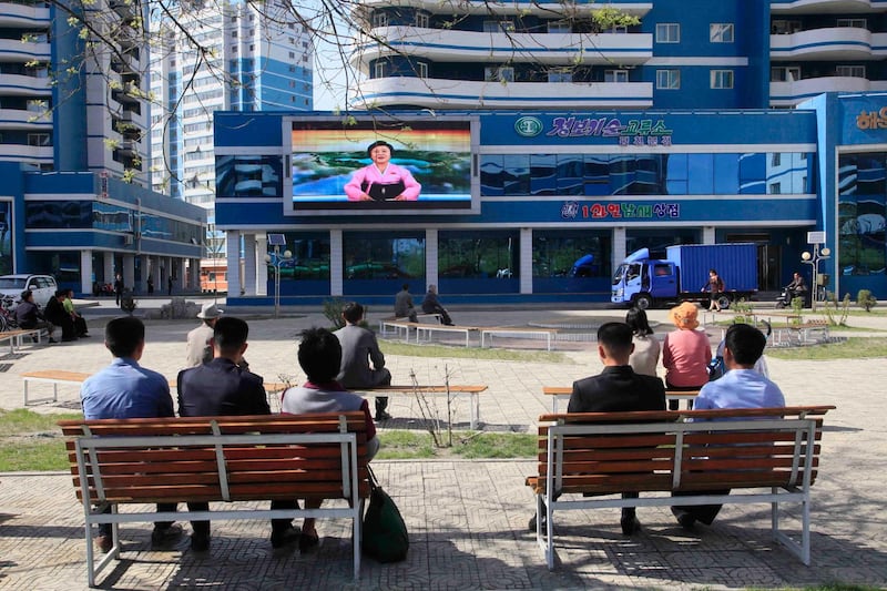 North Koreans watch as their country's most famous newscaster announces leader Kim Jong Un's proposal to suspend nuclear tests and long-range missile launches on a giant screen on Pyongyang's newly built Mirae Scientists' Street Saturday, April 21, 2018. Kim is to hold a summit with South Korea's president next week and with U.S. President Donald Trump in late May or June. (AP Photo/Jon Chol Jin)