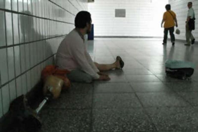 A disabled man begs in a pedestrian underpass in Beijing.