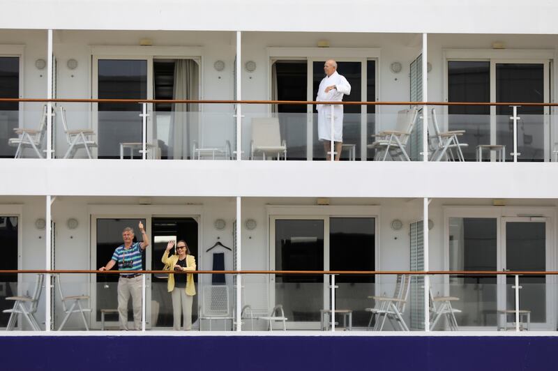 Tourists wave as the ‘Europa’ passenger liner arrives in South African waters off Cape Town as the new coronavirus variant Omicron spreads in other countries. Reuters