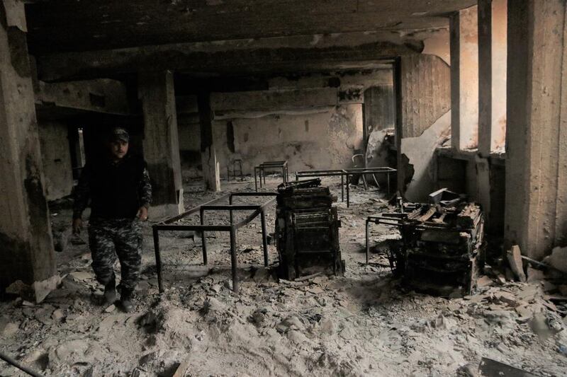 A member of the Federal Police walks past the gutted tables and printers used by ISIL to put together its Al Naba newspaper. Florian Neuhof for The National