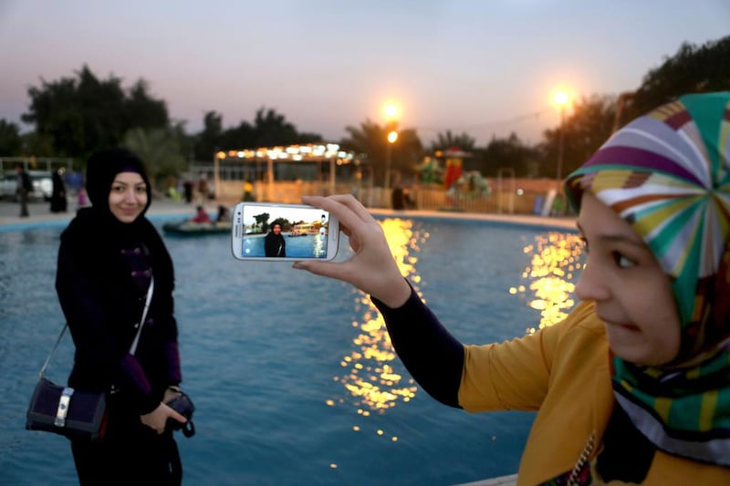A mobile-phone moment in a Baghdad park. Patrick Baz / AFP 