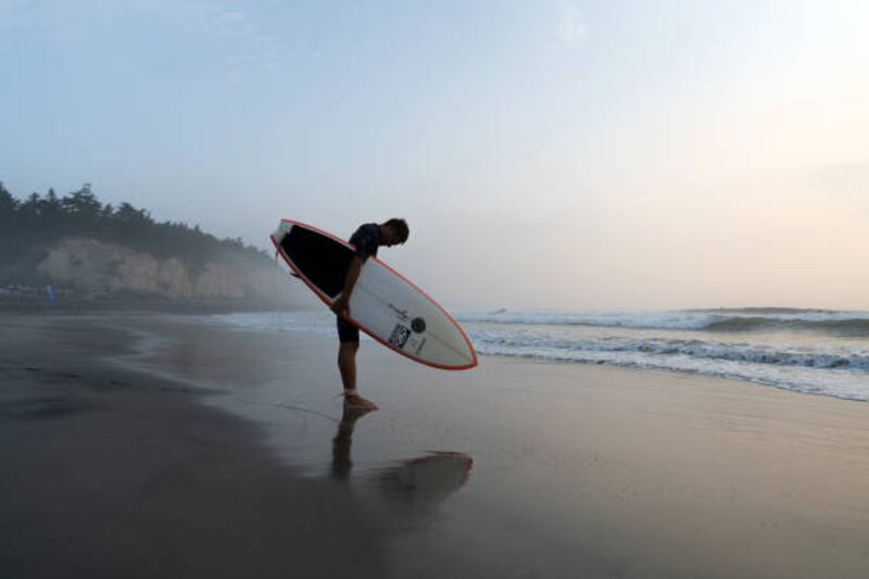 A surfer observes a moment of silence during the Iwasawa Surfing Games at Iwasawa beach, Fukushima. Getty Images