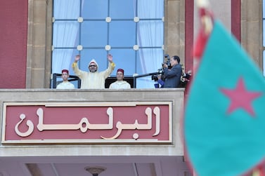 Moroccan King Mohammed VI flanked by his brother Prince Moulay Rachid right and the crown prince Moulay Hassan left waves to the crowd. Moroccan Royal Palace via AP
