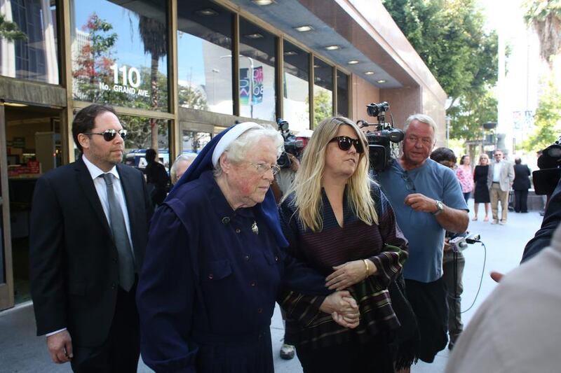 Sister Rita Callanan, center, is escorted by businesswoman Dana Hollister out of Los Angeles Superior Court on Thursday, July 30, 2015. AP Photo / Anthony McCartney