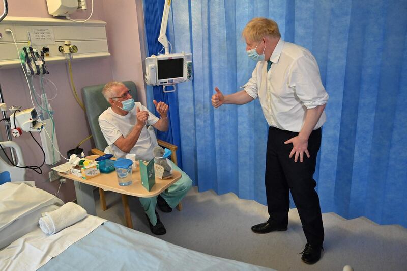 Boris Johnson speaks to patient Lewis Clark as he visits Colchester hospital. AFP