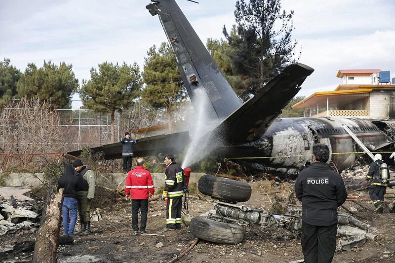 Firefighters and security forces gather amidst the debris of a Boeing 707 cargo plane. AFP