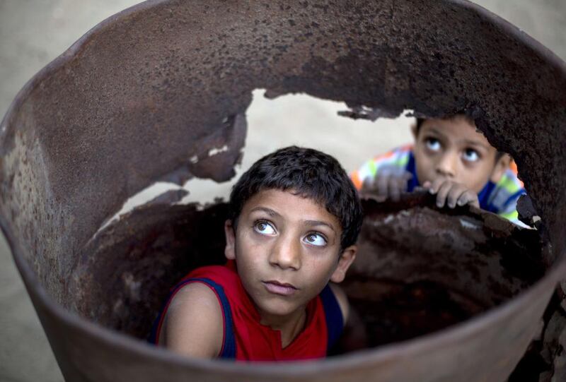 Palestinian boys play in a barrel outside their home in Beit Lahia, in the northern of Gaza Strip. Mohammed Abed / AFP 