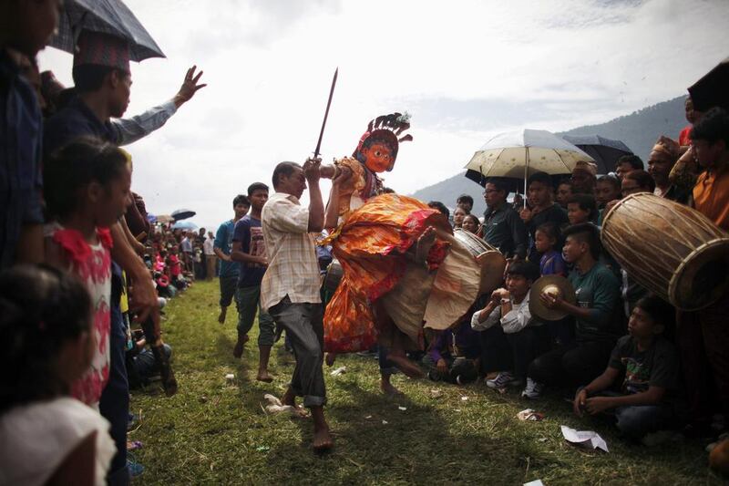 Nepalese devotees carry a dancer wearing a mask of a deity as he perform during Shikali festival in Khokana, Lalitpur, Nepal. Niranjan Shrestha / AP Photo