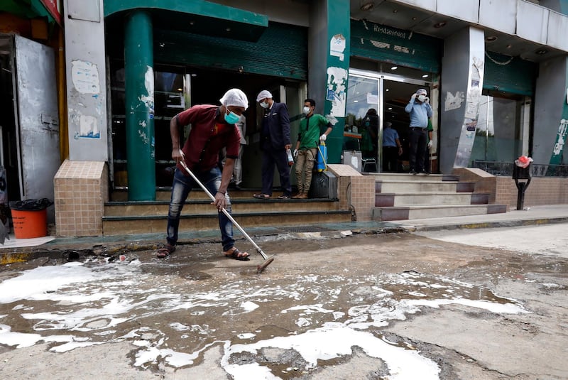 A Yemeni man cleans the entrance to a restaurant with a disinfecting liquid, amid concerns over the spread of the coronavirus. EPA