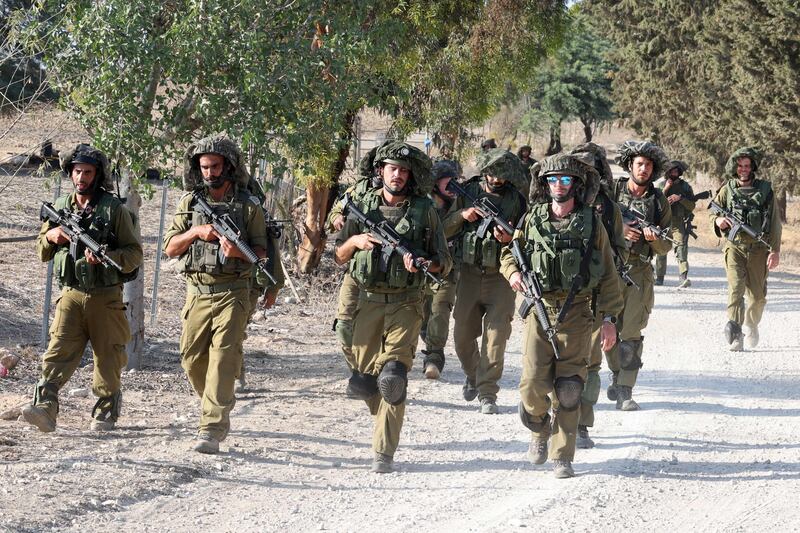 Israeli troops at an undisclosed location along the border with the Gaza Strip on October 19. AFP