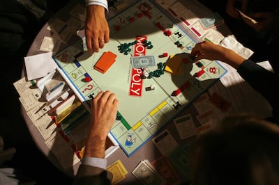 People move game pieces on the board game Monopoly, manufactured by Hasbro Inc., at the New York University Real Estate Institute Monopoly event on Tuesday, November 14, 2006. Photographer: Michael Nagle/Bloomberg News.
