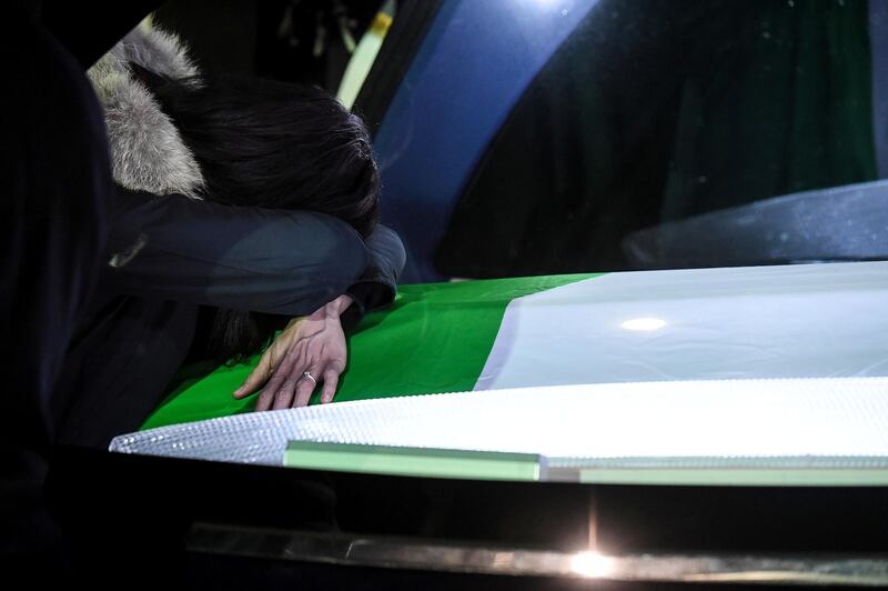 A woman cries on one of the two coffins. Reuters