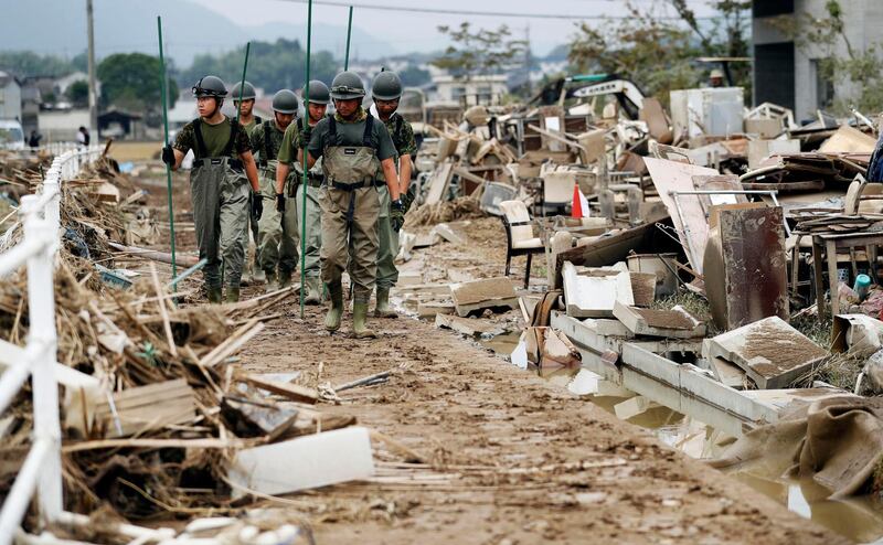 Japan Ground Self-Defense Force members search missing people after flooding caused by heavy rains in Kurashiki, Okayama prefecture, southwestern Japan, Thursday, on July 12. Kyodo News via AP