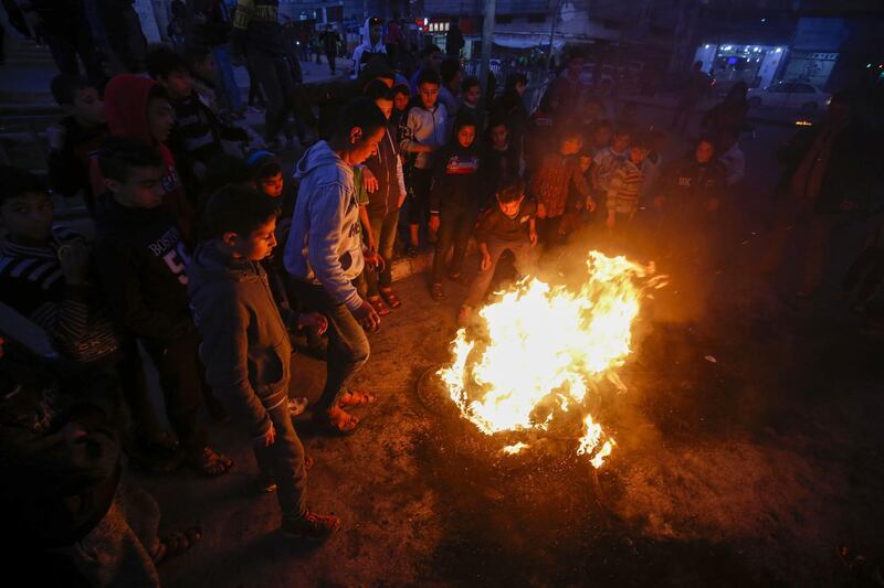 Palestinian demonstrators chant slogans as they stand by flaming tyres during a protest against US President Donald Trump's expected peace plan proposal in Rafah in the southern Gaza Strip. AFP