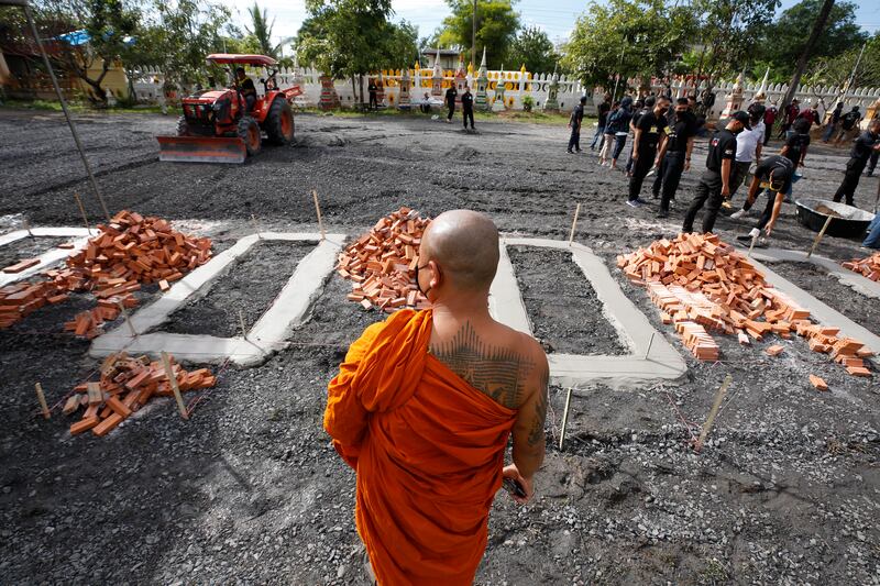 A Thai Buddhist monk watches the preparation of a site for the mass cremation rite for those killed in a childcare centre mass killing, at a temple in Nong Bua Lamphu province, north-east Thailand.  At least 37 people were killed, mostly children, while another 12 were injured when a former policeman attacked the centre, and later killed his wife and their child, then himself, police said. EPA