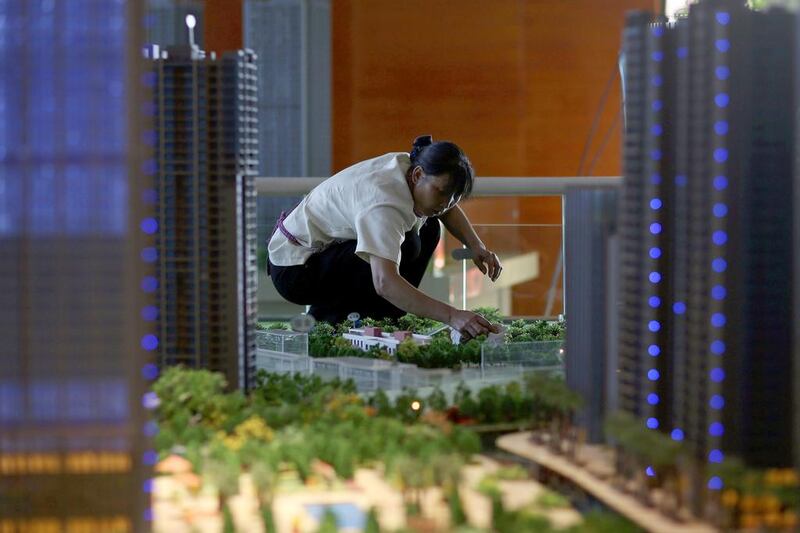 A worker cleans models of apartments at a showroom in Kunming, Yunnan province. Chinese banks’ bad loan ratio rose to 1.08 per cent at the end of June from 1.04 per cent in March, adding to concerns a slow economy and cooling property market could weigh on banks and brew up financial risks. Wong Campion / Reuters