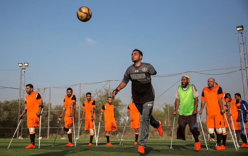 Palestinian goal keeper Islam Amoun (center) and other players during a practice session for Gaza's first amputee football team held at the municipal ball field of Deir Al Balah ,Gaza on July 16,2018. Islam was critically injured and lost his left arm by an Israeli air strike nearby his home during the war in 2014. (Photo by Heidi Levine for The National).