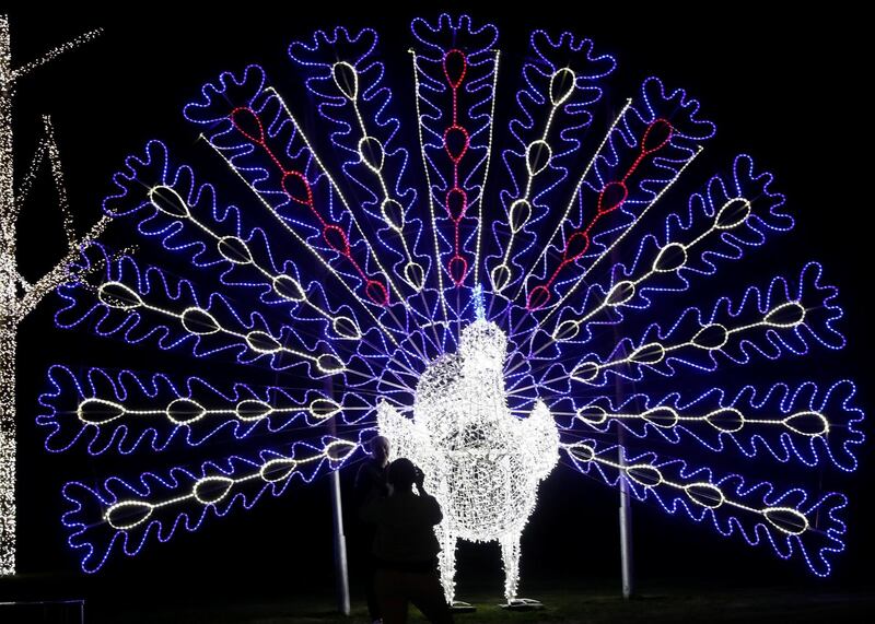 Egyptians take a photo near an illumination in the shape of a peacock ahead of New Year celebrations, at the pedestrian area of Soho Square in the Red Sea resort of Sharm el-Sheikh, south of Cairo, Egypt. Reuters