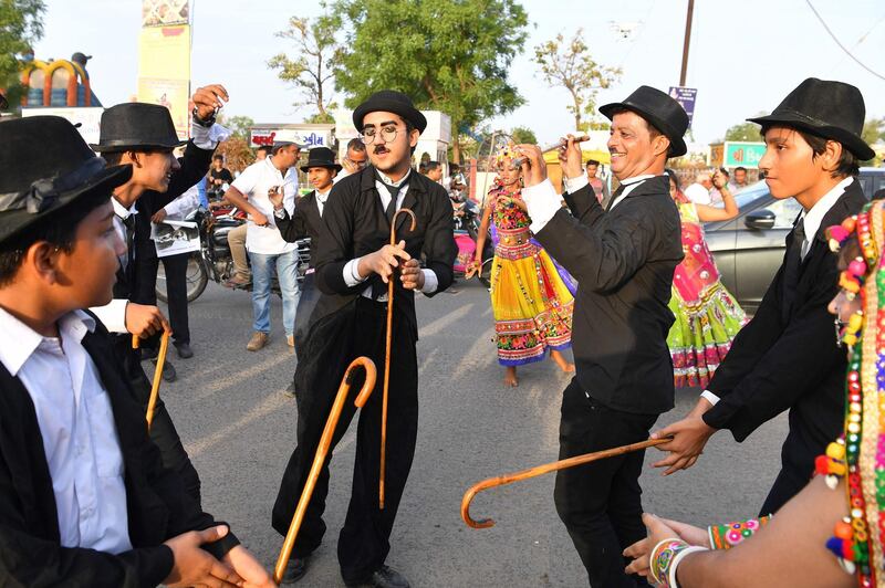 Talin Mavani, a Charlie Chaplin impersonator, breaks into a jig with other impersonators during an event commemorating the legendary actor's 129th brithday in Adipur, Gujarat, India. Indranil Mukherjee / AFP