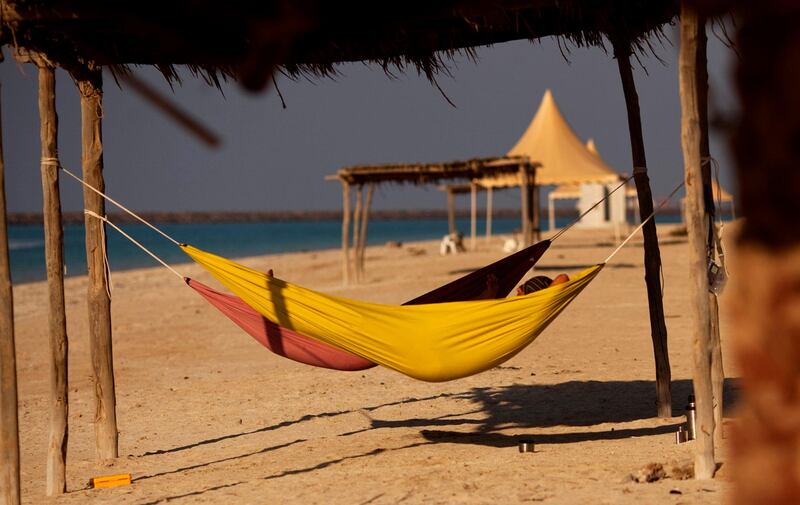 French ex-pat Herbert and his friend Pascal lay in hammocks between sailing on Lulu Island in Abu Dhabi on December 16, 2011. Three years ago the public ferry to the island stopped regular service and since has become littered with rubbish from people failing to pick up after themselves. Christopher Pike / The National

